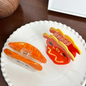 Cute sushi and red cartoon character acetate hair claws on a white vintage ceramic plate