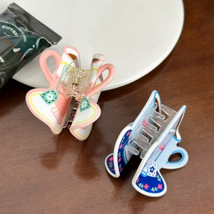 Molle per capelli a forma di tazza da caffè in acrilico rosa e blu su un tavolo