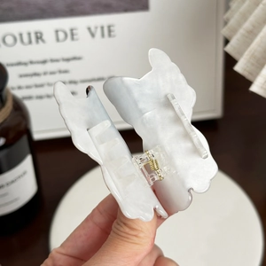 Pince à cheveux papillon élégante avec finition nacrée et ressort en métal doré