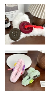 Détail d'une pince à cheveux en peluche avec boutons colorés sur une table en bois sombre