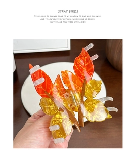 Macro detail of autumn leaf resin hair claw clip with warm orange gradient tones