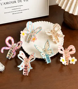Détail de pinces à cheveux en acétate avec motifs de fleurs, nœuds et imprimés cerise