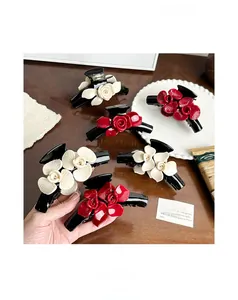 Macro detail of high-quality acetate floral hair claw with red roses on a black base