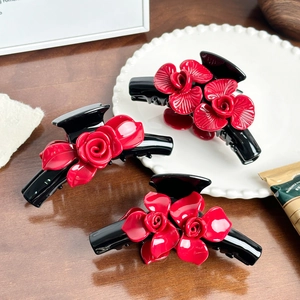 Three-piece set of black acetate hair claws featuring realistic 3D red rose flowers