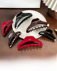 Detail of assorted large acetate hair claws with gold France Handmade logo engraving