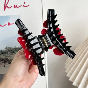 Elegant large floral hair claw clip in black and red acetate with gold spring