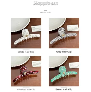 Detailed view of grid-patterned acetate hair claws in white, grey, red, and green
