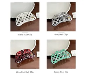 Detail of four retro hollow hair claws in white, grey, burgundy, and green on wood