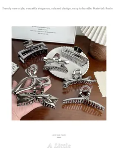 Detailed view of large silver resin hair claw clips in star and geometric shapes