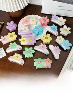 Nahaufnahme von Blumen Haarklammern in Macaron-Farben auf einem Holztisch