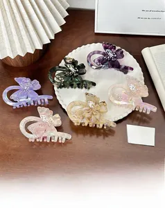 Détail des pinces à cheveux papillon en acétate avec strass sur un bureau en bois