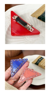 Détail d'une pince à cheveux triangle en acétate avec strass et clip anti-glisse bec de canard