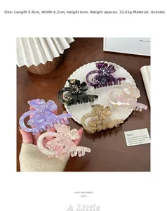 Vue détaillée de pinces à cheveux papillon en acétate coloré avec strass incrustés