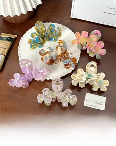 Detail of floral hair claws in six marble patterns with centered crystal accents