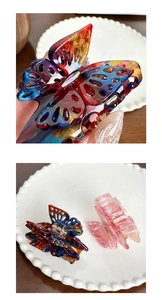 Gros plan de pinces à cheveux papillon évidées aux motifs de marbre colorés élégants