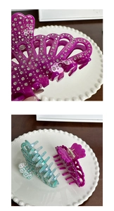 Macro detail of rhinestone inlay on purple and teal marble acetate hair claw clips