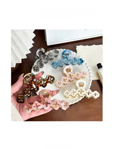 Vue détaillée de grandes pinces à cheveux en acétate aux motifs écaille et marbre