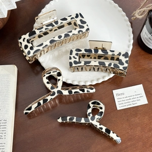 Set of 4 vintage cow print hair claws in rectangular and spiral styles on white plate