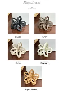 Detail of matte frangipani hair claw clips in black, grey, beige, and cream colors