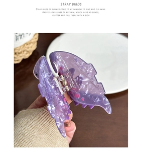 Detailaufnahme der lila transparenten Dinosaurier-Haarklammer mit rosa Punkten und Metallfeder