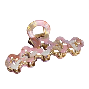Grande pince à cheveux en acétate marbré rose et structure en métal doré pour femme