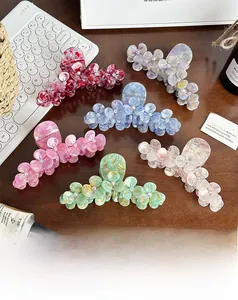 Detailed shot of six colorful flower-shaped acetate hair claws with sparkling rhinestones