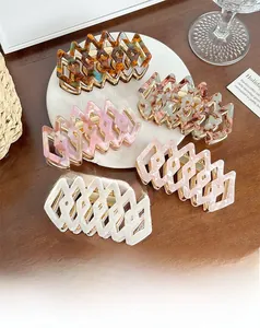 Detail of five geometric tortoiseshell acetate hair claws in various marble patterns