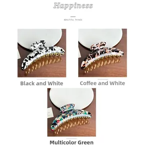 Three acetate hair claws in marble and tortoiseshell patterns with gold metal teeth