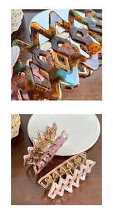 Macro detail of geometric acetate hair claws with marble and tortoiseshell patterns