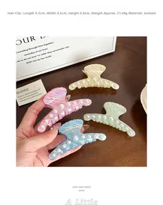 Detailed view of iridescent shell-shaped hair claws made of premium acetate with pearls