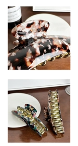 Detailed macro of acetate hair claws showing tortoise shell texture and gold metal spring