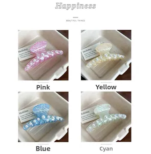Detail view of shell texture acetate hair claws with white pearls in four colors