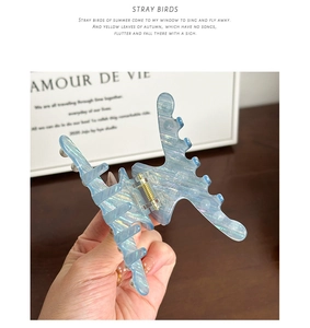 Detail of a medium cloud blue acetate hair claw clip with marble shell texture
