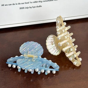 Elegant shell-shaped pearl hair claws in blue and beige with iridescent finish