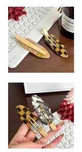 Détail de grandes barrettes en acétate avec motifs rétro en damier et résine tourbillonnante
