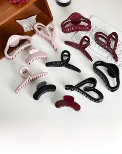 Detail of matte heart and geometric hair claws in pink, burgundy and black colors