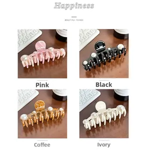 Detail of four acetate pearl hair claws in pink, black, coffee, and creamy white