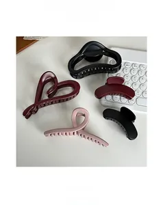 Detailed view of various resin hair claws in black, burgundy and soft pink colors