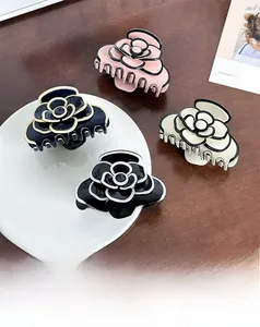 Detailed top view of acetate camellia flower hair claws in four elegant color variations