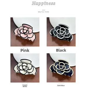 Detail view of acetate camellia hair claws in pink, black, cream, and navy blue options