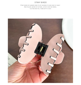Detailed view of pink butterfly claw clip with strong gold metal spring mechanism