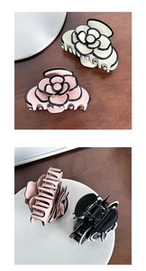 Detailed close-up of acetate camellia hair claw clips in pink, white, and black colors