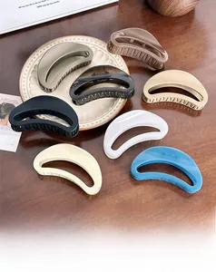 Detailed macro view of large 12cm crescent moon hair claw clips in various elegant matte colors