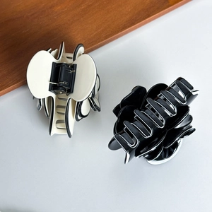 Elegant set of two camellia acetate hair claws in black and cream white with floral petal design
