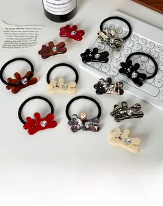 Gros plan de barrettes ours mignonnes et élastiques avec strass en forme de cœur colorés