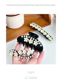 Détail de pinces à cheveux en acétate avec fleurs en diamant incrustées et perles