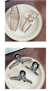 Detail of beige polka dot and black striped bow claw clips on a vintage ceramic plate