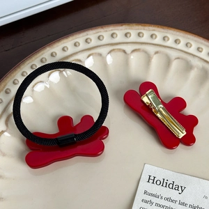 Ensemble de pince à cheveux fleur rouge et chouchou sur une assiette pour femmes