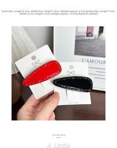 Main tenant des pinces à cheveux en acétate avec strass rouge et noir, attaches ressort