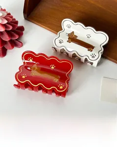 Detail of red and cream acetate dachshund hair claws with wavy edges and cute dog prints